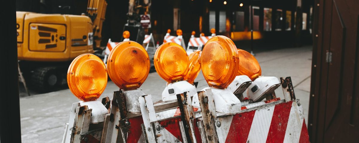 orange lights on top of white and red metal bars